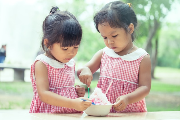 zwei kleine Mädchen essen Eis zusammen