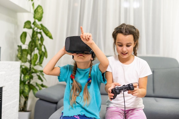 zwei kleine Mädchen mit Brille von Virtual-Reality-Headset. Konzept moderner Technologien