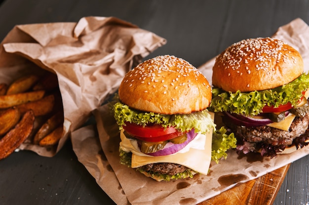 Zwei köstliche, köstliche hausgemachte Burger zum Hacken von Rindfleisch. auf dem Holztisch.