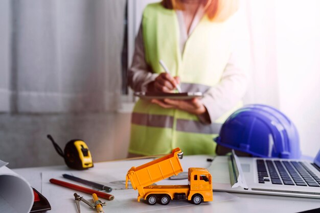 Zwei Kollegen diskutieren über Datenarbeit und Tablet-Laptop mit einem Architekturprojekt auf der Baustelle am Schreibtisch im Büro