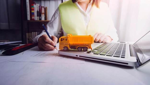 Zwei Kollegen diskutieren über Datenarbeit und Tablet-Laptop mit einem Architekturprojekt auf der Baustelle am Schreibtisch im Büro