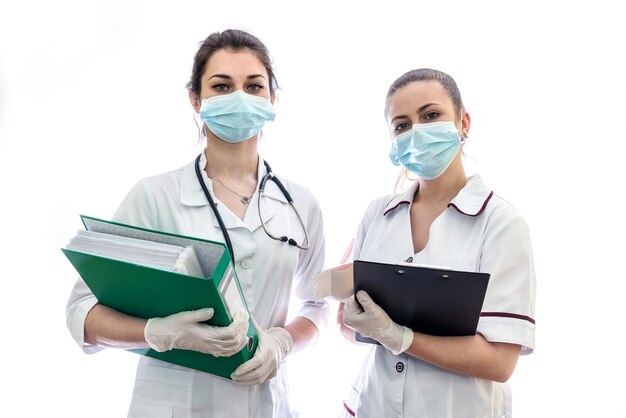 Zwei Krankenschwestern, die Dokumente lokalisiert auf weißer Wand halten