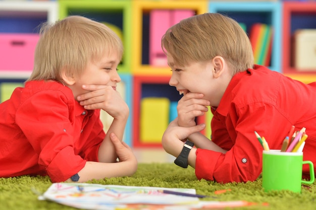 Zwei lächelnde Jungen in roten Hemden, die Spaß haben