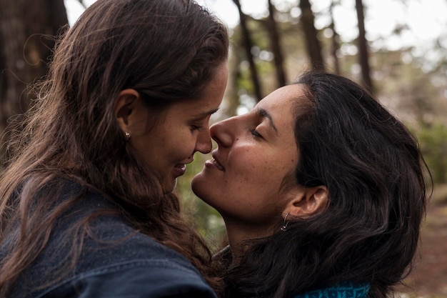 Zwei lateinamerikanische Frauen küssen Konzept des Verliebens