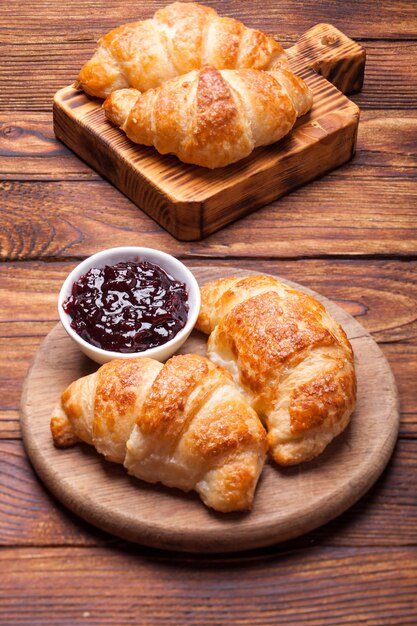 Zwei leckere Croissants auf einem Holzbrett