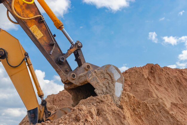 Zwei leistungsstarke Bagger arbeiten gleichzeitig auf einer Baustelle, sonniger blauer Himmel im Hintergrund Baumaschinen für Erdarbeiten