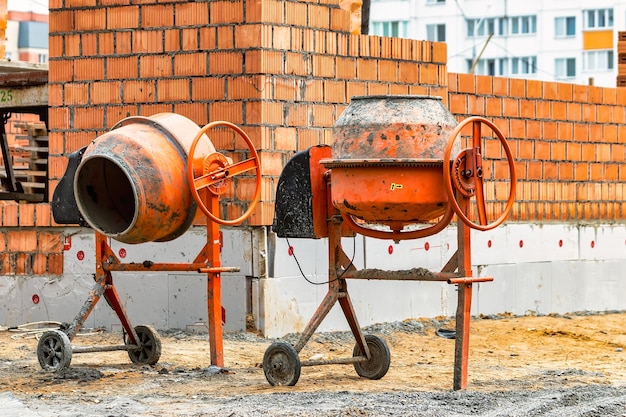 Zwei leistungsstarke industrielle Betonmischer auf einer Baustelle Mischen von Beton und Mörtel vor Ort Baumaschinen