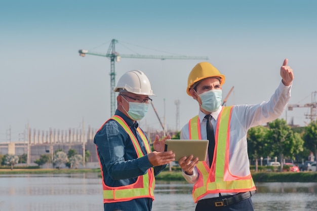 Zwei Leute, die am Bau der Baustelle arbeiten und dann über ein Bauprojekt sprechen