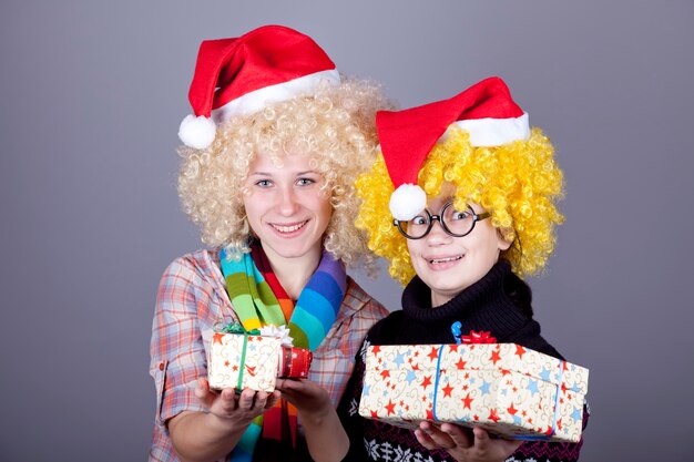 Zwei lustige Mädchen mit Weihnachtsgeschenken.