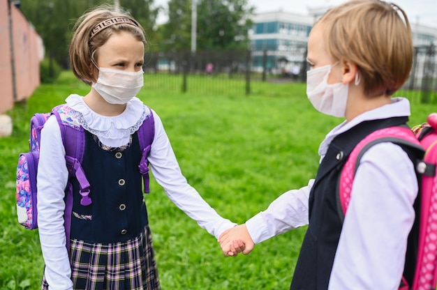 Zwei Mädchen am ersten Schultag mit Schutzmasken