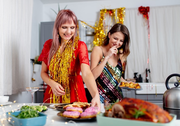 Zwei Mädchen, die Spaß mit Donuts in der Küche nach einer Party haben