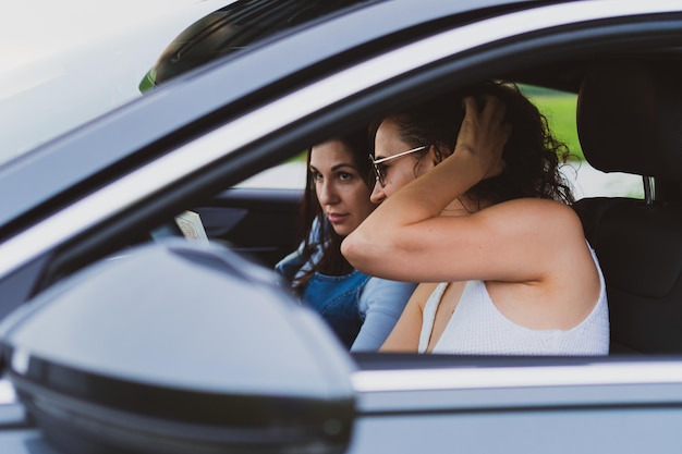 Zwei Mädchen fahren in einem Auto durch die Straßen und sehen sich die Karte an Urlaubskonzept