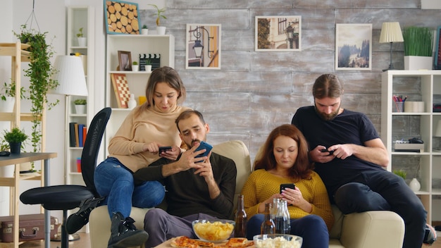 Zwei Mädchen lachen beim Spielen von Videospielen mit ihrem Freund im Fernsehen mit drahtlosen Controllern.