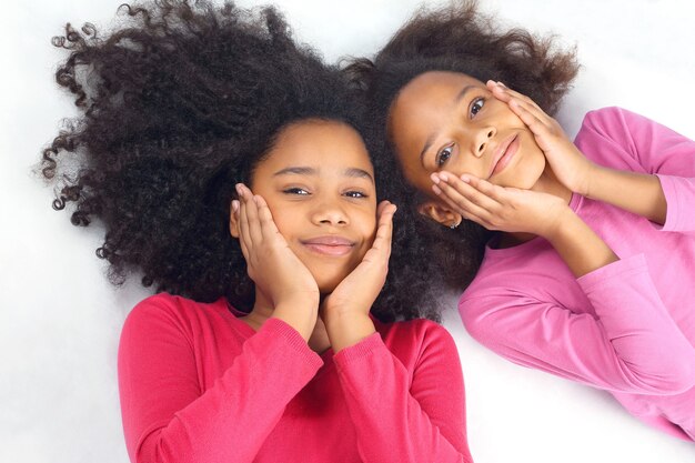 Zwei Mädchen liegen nebeneinander Haare. unbeschwerte und glückliche Kinder