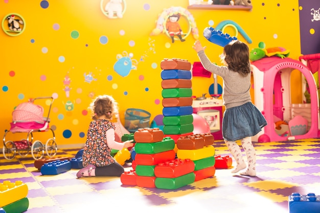 Zwei Mädchen spielen mit großen Steinen im Spielzimmer