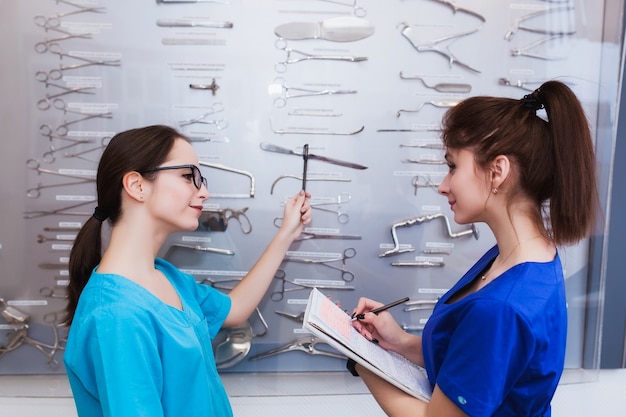 Zwei Mädchenkrankenschwestern studieren chirurgische Instrumente. Medizinische Ausbildung