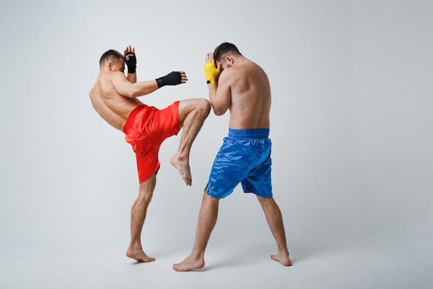 Zwei Männer Boxer kämpfen Muay Thai Kickboxen weißen Hintergrund