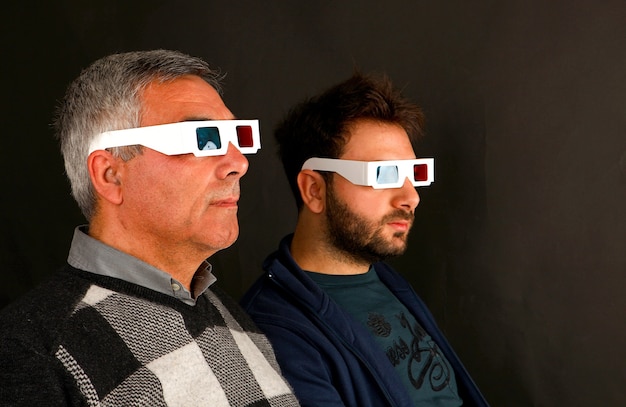 Zwei Männer, die 3D-Brille auf schwarzer Wand tragen