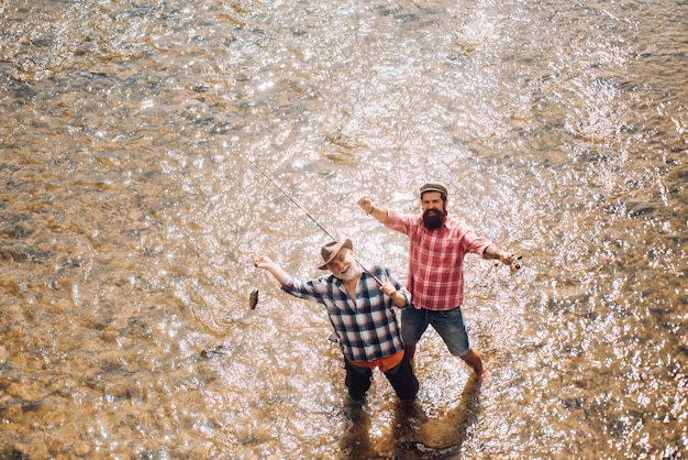 Zwei Männer Freunde Angeln Fliegenfischen Angler macht Cast Stehen im Flusswasser Alte und junge Fischer