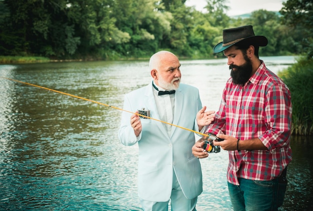 Zwei Männer Freunde Fischer Angeln am Fluss Alter Vater und Sohn mit Rutenangeln am Flussufer Recreati