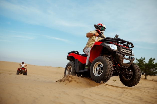 Zwei Männer in Helmen fahren auf einem ATV, Action-Ansicht