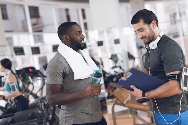 Zwei männer kommunizieren im fitnessstudio.