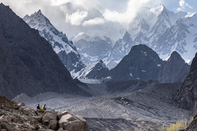 Foto zwei männer sitzen am rande der gletscherberge