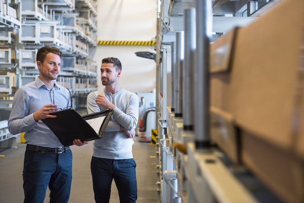 Foto zwei männer stehen im fabriklager