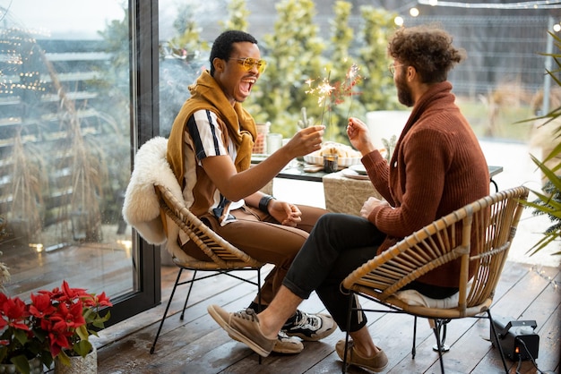 Foto zwei männliche freunde feiern mit wunderkerzen im hinterhof