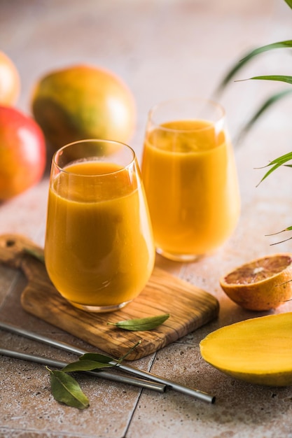 Zwei Mango-Lassi oder Kesar-Milch in Gläsern Indisches gesundes ayurvedisches Kaltgetränk mit Mango Frische Lassi aus Joghurtwasser, Gewürzen, Früchten und Eis