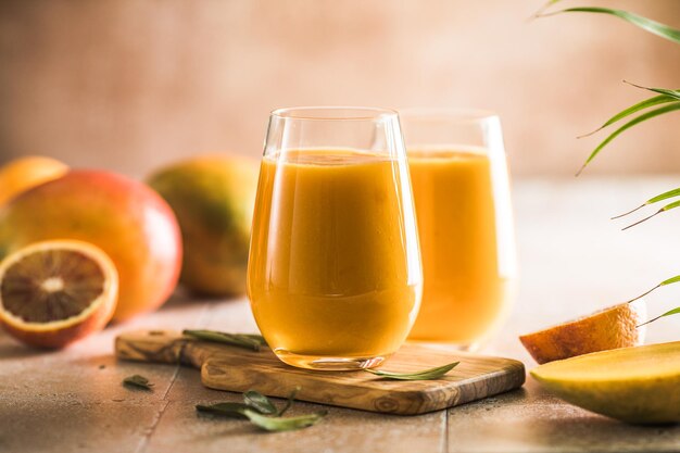 Foto zwei mango-lassi oder kesar-milch in gläsern indisches gesundes ayurvedisches kaltgetränk mit mango frische lassi aus joghurtwasser, gewürzen, früchten und eis