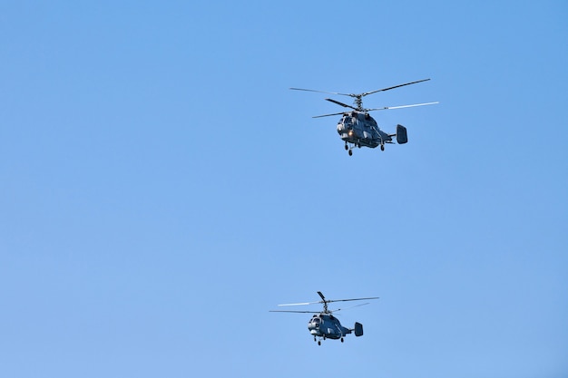 Zwei Militärhubschrauber fliegen in strahlend blauem Himmel, während sie einen Demonstrationsflug durchführen, ein Kunstflugteam führt einen Flug bei einer Flugschau durch, Kopierraum