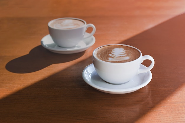 Zwei morgendliche Tassen Kaffee auf Holz