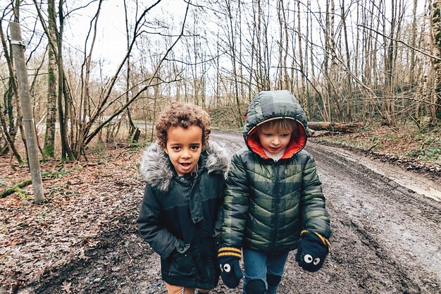 Zwei multiethnische kleine Jungen, die an kalten Tagen im Freien spazieren