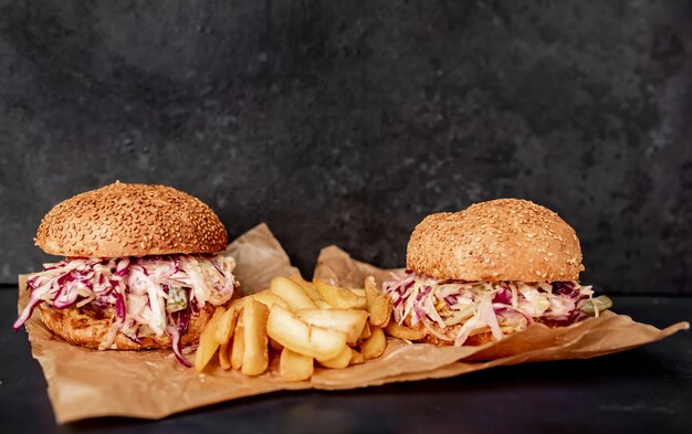 zwei Ochsenschwanzburger mit Kohlfritten auf einem Steintisch