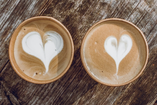 Zwei Pappbecher Kaffee mit Herzform Latte Art