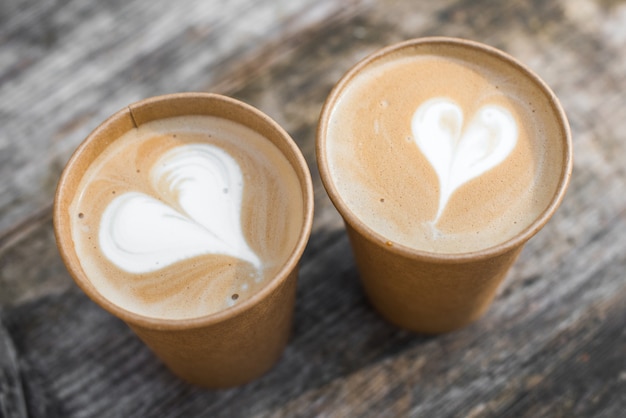 Zwei Pappbecher Kaffee mit Herzform Latte Art