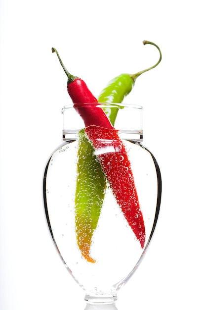 Zwei Paprika im Glas Sprudelwasser, Isolated on White im Studio