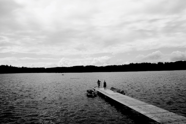 Zwei Personen auf einem Holzsteg über dem See
