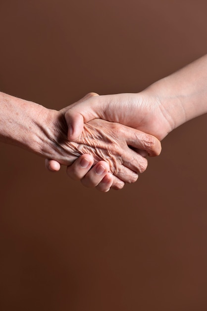 Zwei Personen aus unterschiedlicher Generation schütteln sich in einer Vereinbarung die Hand