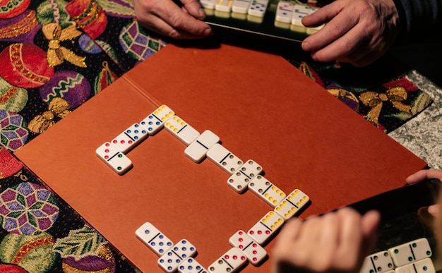 Zwei Personen, die Domino in der Küche auf dem Lampenlicht spielen