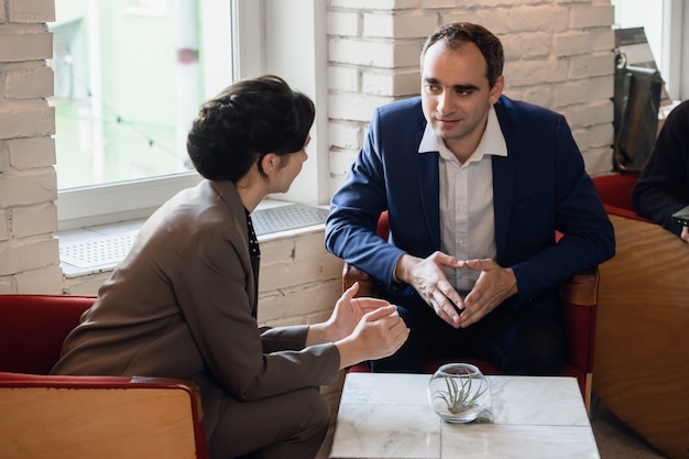 Zwei Personen diskutieren Geschäftsfragen in einer informellen Umgebung