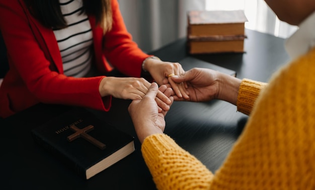 Zwei Personen lesen und studieren zu Hause die Bibel und beten zusammenDas Wort Gottes mit Freunden studierenxA