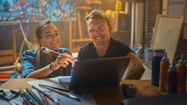 Zwei Personen schauen in einer Werkstatt auf einen Laptop