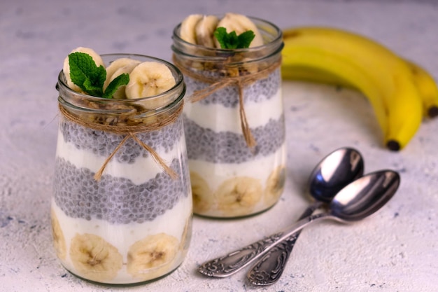 Zwei Portionen Bananen-Chia-Pudding mit Müsli Gesundes Snacks-Konzept