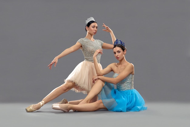 Zwei professionelle Ballerinas sitzen im Studio auf dem Boden