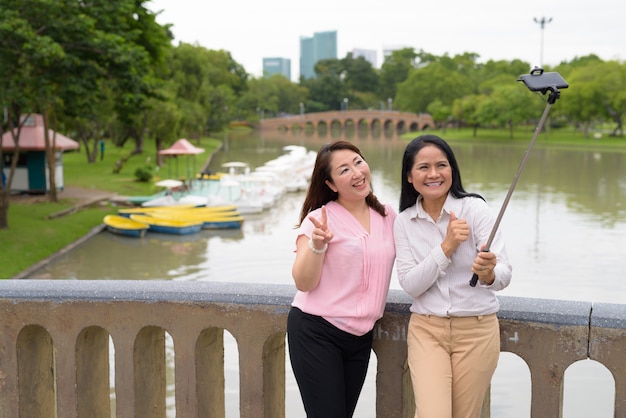 Zwei reife asiatische Frauen, die zusammen im Park entspannen