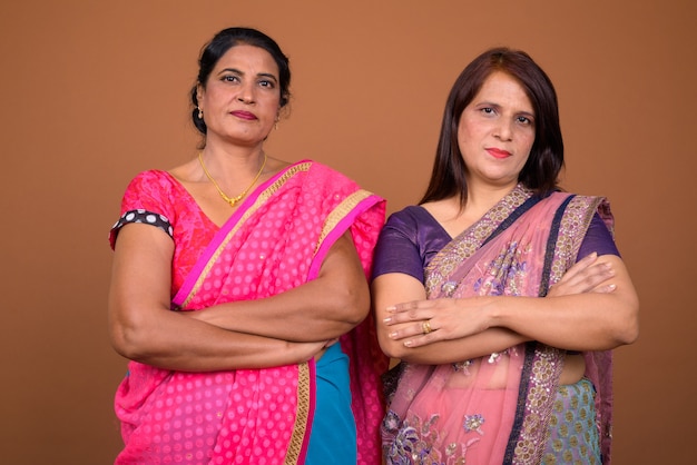 zwei reife indische Frauen, die traditionelle indische Sari-Kleidung zusammen tragen