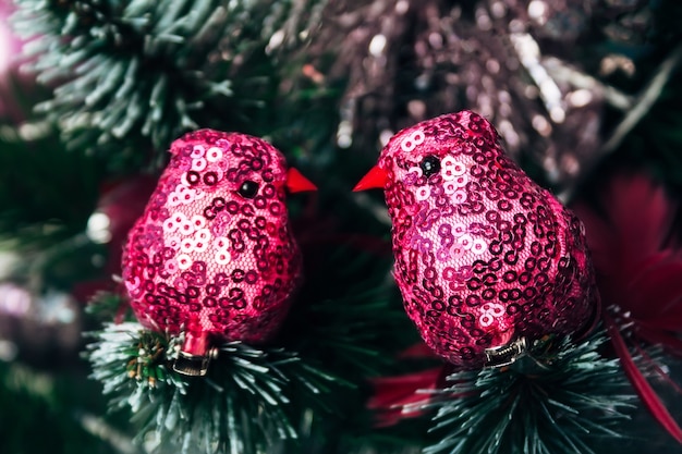 Zwei rosa Textilvögel mit Funkeln auf künstlichem Weihnachtsbaum