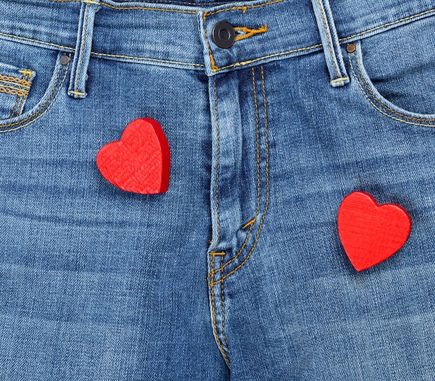 Zwei rote hölzerne Herzen auf Blue Jeans